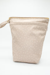 Large wet bag in print Beehave. Beautiful bronze background with a subtle bee print, 2 pockets with gold zip detail. Flat bottom and handy domed handle.