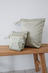 Large wet bag in print Field of Hearts. Beautiful khaki background with tiny hearts scattered, 2 pockets with gold zip detail. Flat bottom and handy domed handle.