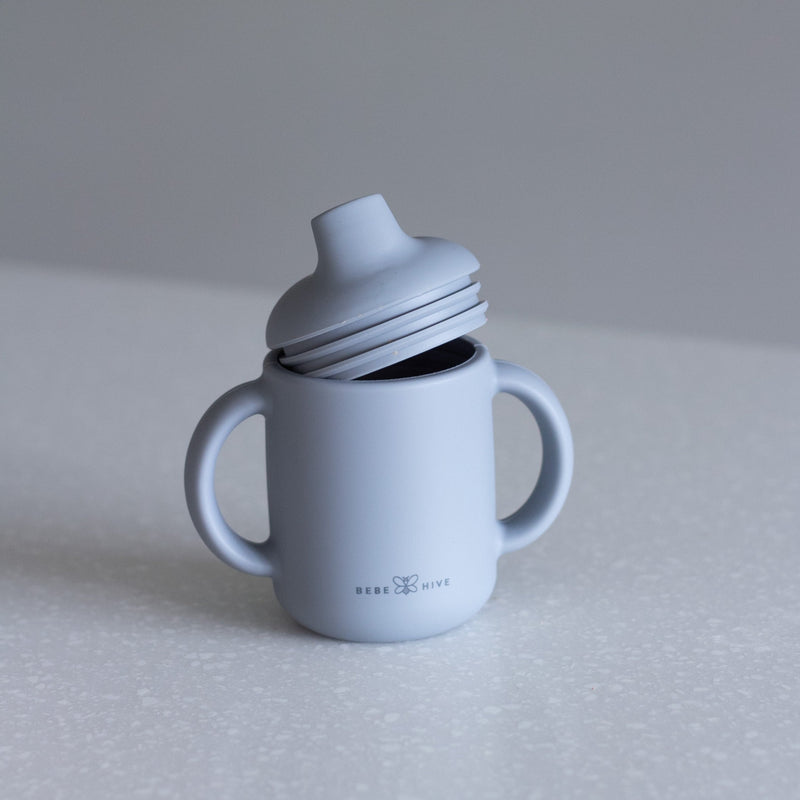 Silicone sippy cup in blue grey fog, baby feeding essential, shows double ridge seal on lid, double handled cup