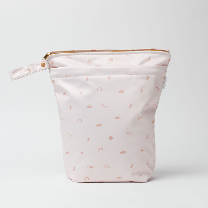 Large wet bag in print Sky High. Soft nude background with a print of clouds, moons, planets, stars and suns., 2 pockets with gold zip detail. Flat bottom and handy domed handle