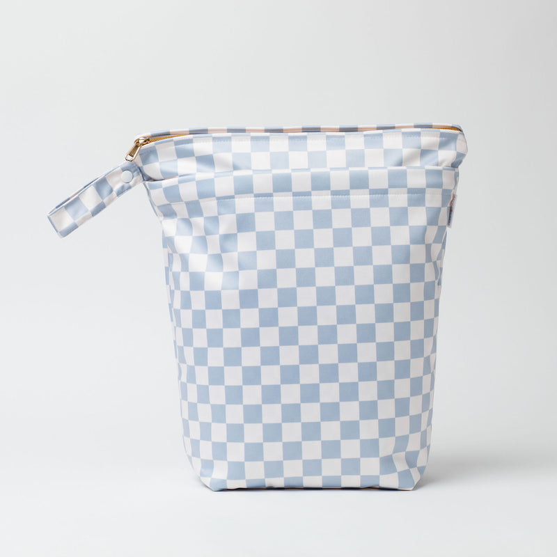 Large wet bag in print So checked out, print is soft blue and white check, 2 pockets with gold zip detail. Flat bottom and handy domed handle