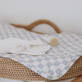 Styled photo of Reusable change mat in a blue and white check, photo also features bebe hive reusable cloth wipes. Luxe quilted finish with a soft bamboo terry, machine washable, perfectly paired with modern cloth nappies, bee details on snaps. 